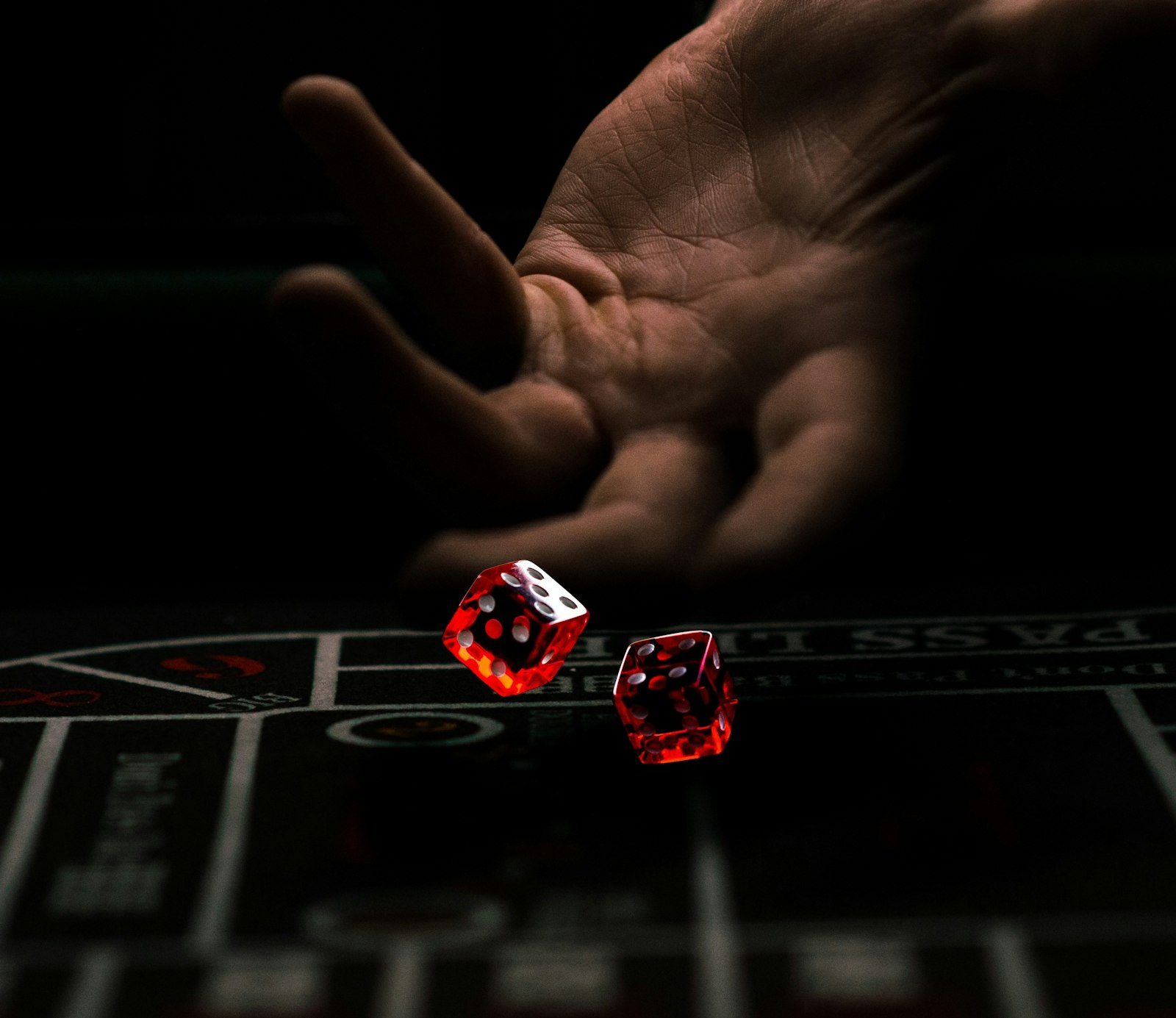 Dice thrown across a dark casino table